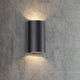 Rold LED Außen-Wandleuchte IP44 Schwarz an einer Wand, minimalistische Design mit Lichtstrahlung nach oben und unten.