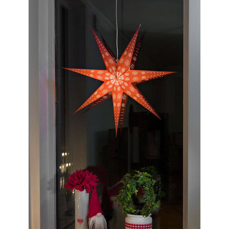 Red paper star, perforated with a white printed pattern, 7 points, without light source, for window decoration.
