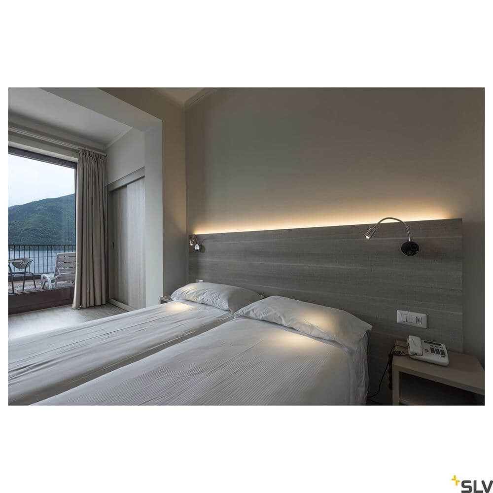Gemütliches Schlafzimmer mit zwei Betten, moderner Beleuchtung und Balkonansicht in einem Hotelzimmer.