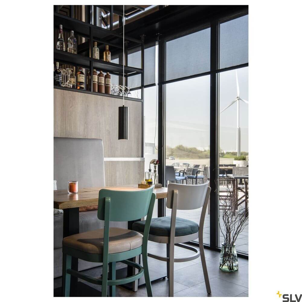 Moderne Einrichtung mit Anela Reflektor 28° Silber am Tisch und eleganten Stühlen in einem hellen Café.