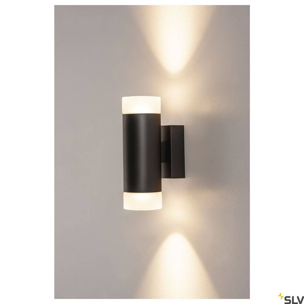Astina Wandlampe QPAR51 Up & Down Schwarz an einer Wand montiert mit warmem Licht.