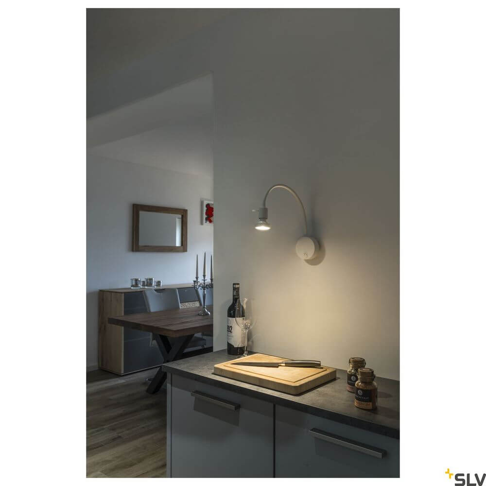 Dio Flex Plate QPAR51 Wandlampe Weiß in modernem Innenraum, elegant über einem Tisch positioniert.