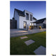 Eskina Double LED Pollerleuchte Frame IP65 beleuchtet stilvolles modernes Haus mit Garten und Terrasse.
