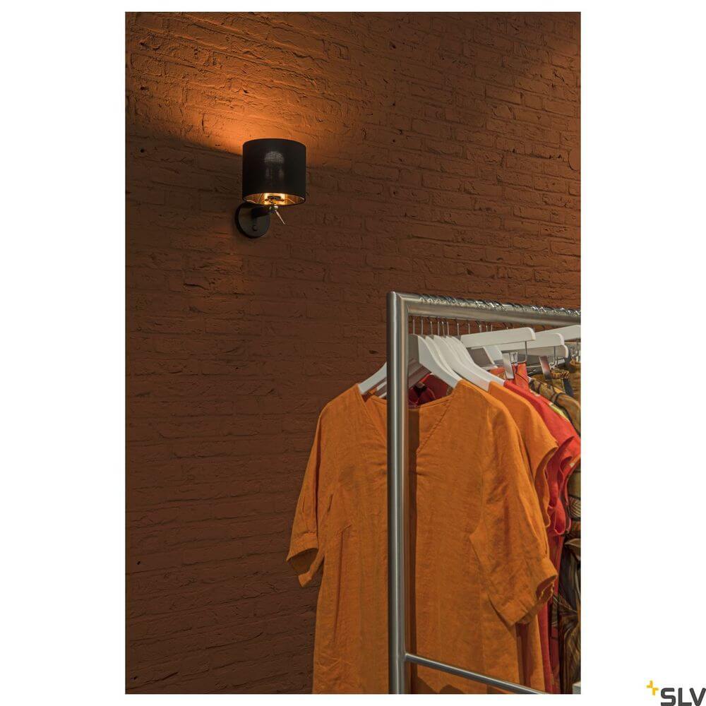 Fenda Wandleuchte E27 Schwarz (ohne Schirm) an einer Wand über einer Kleiderstange mit modischer Bekleidung.