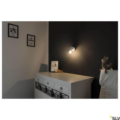 Fitu E27 white wall spotlight on a wall in a stylish room with a wooden dresser and decoration.