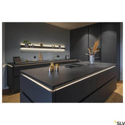 Cuisine moderne avec éclairage Grazia Pro LED Flexstrip 24V 2700-6500K sur les murs et un élégant design noir.