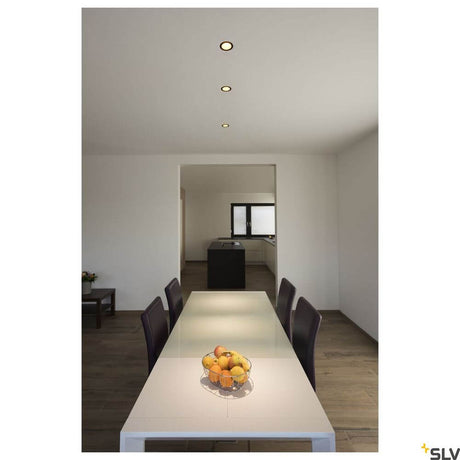 Horn Magna recessed light 3000K black, gold above a modern dining area with a table and chairs.