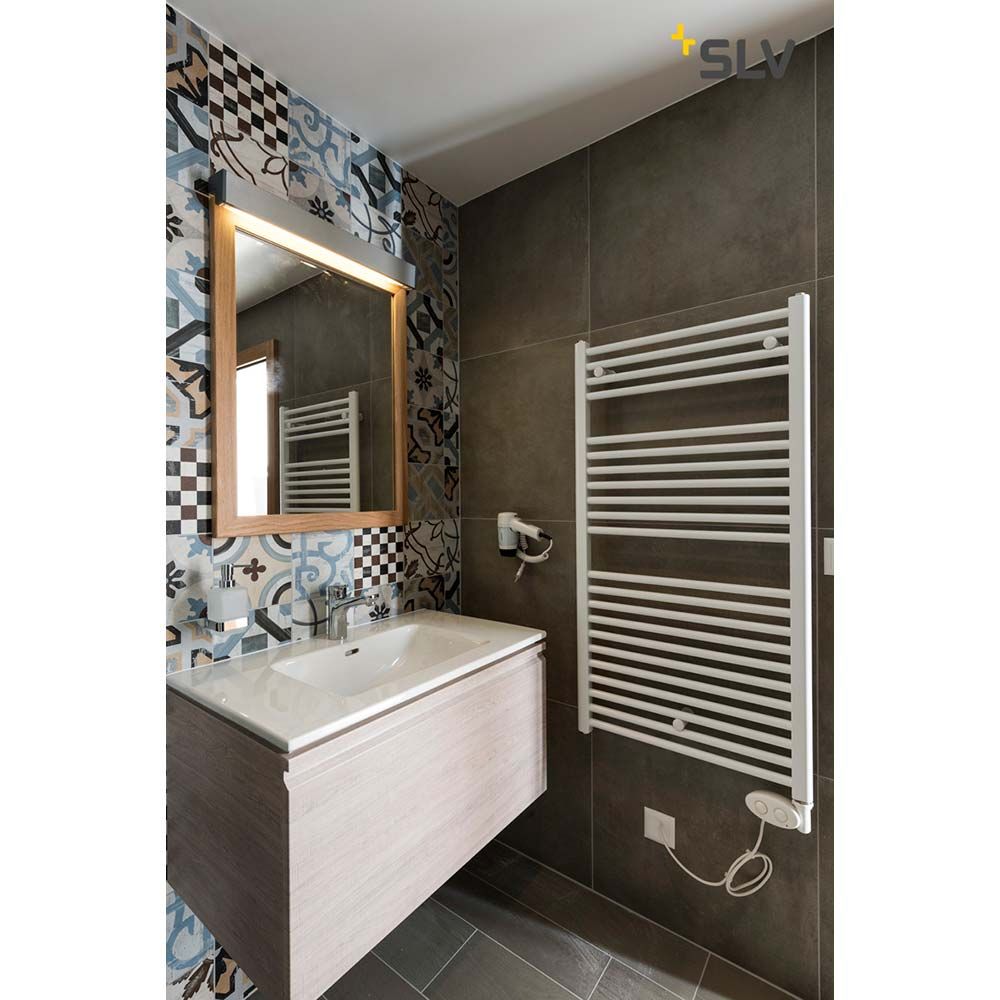 Moderne Badezimmeransicht mit weißem Handtuchheizkörper, Spiegel und stilvollem Waschbecken.