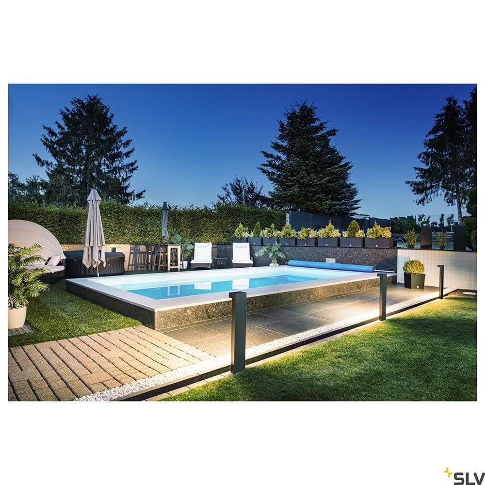 L-Line LED Pollerleuchte Pole Anthrazit CCT IP65 beleuchtet einen eleganten Poolbereich im Außenbereich.