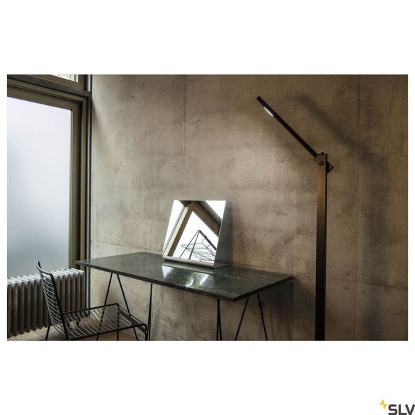 Mecanica Plus FL Büro-Stehlampe 2700-6500K Schwarz neben einem modernen Schreibtisch mit Spiegel.