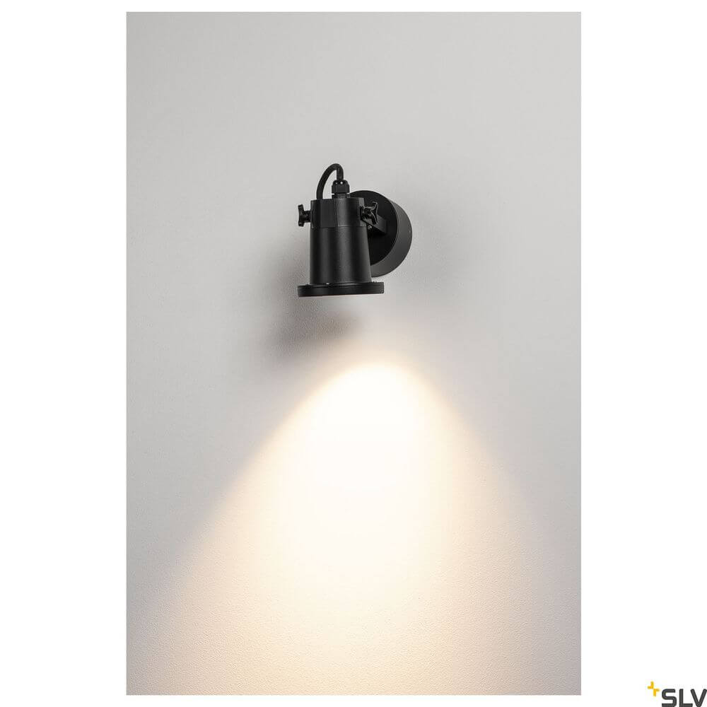Nautilus Außenstrahler QPAR51 Schwarz an einer Wand, strahlendes Licht fokusiert auf die Fläche.