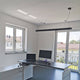 Moderne Büroeinrichtung mit Q-Line Dali Pendelleuchte in Schwarz und zwei Monitoren.