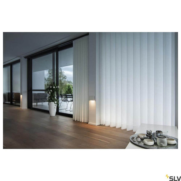 Quad Frame LED applique murale Triac blanc 2700/3000K dans un intérieur moderne avec rideaux transparents.