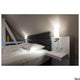Quadrass LED Wandaufbauleuchte neben dem Bett mit modernem Design und warmweißer LED-Lichtquelle.