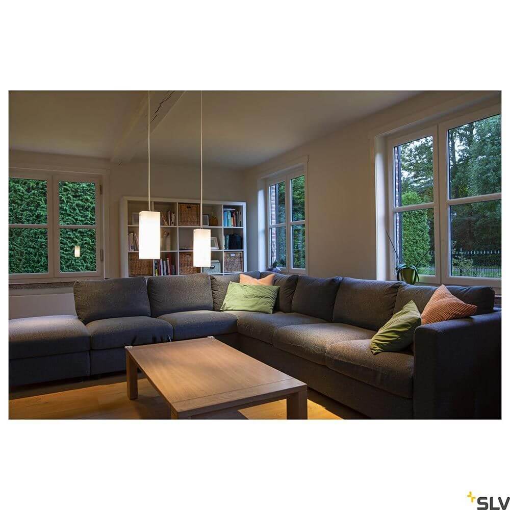 Quadrass Pendelleuchte Weiß über grauem Ecksofa in modernem Wohnzimmer mit Holztisch und grünen Kissen