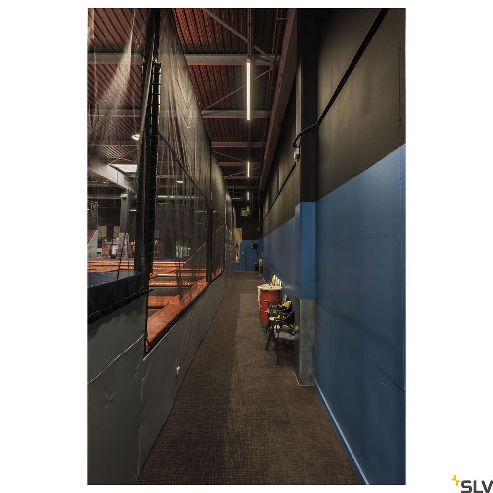 Dunkler Flur mit Netz und LED-Beleuchtung in Sporteinrichtung, zeigt Para Flac Pendelleuchte von SLV.