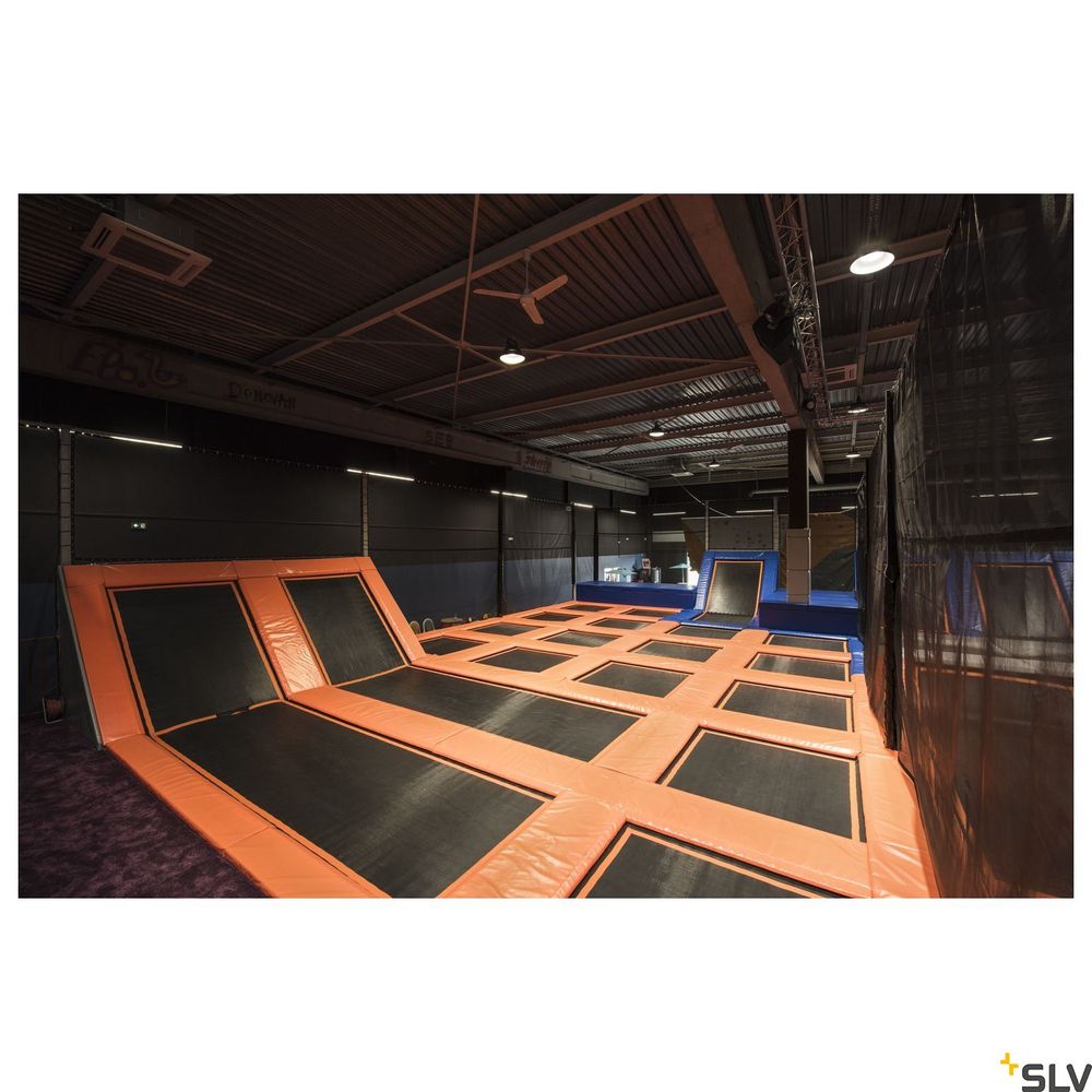 Trampolinbereich in einer Indoor-Jumping-Anlage mit orangefarbenen Trampolinen auf schwarzem Untergrund.