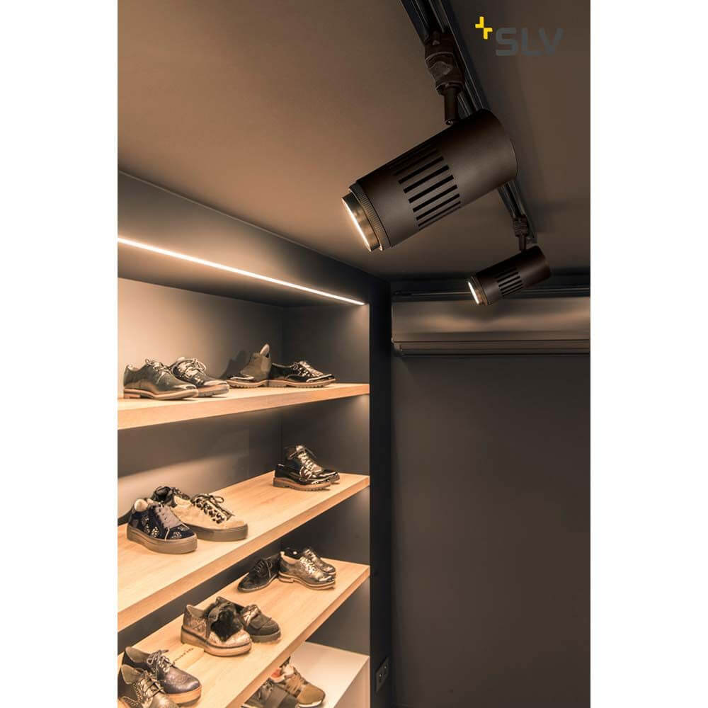 Stuctec LED Zooming Lens Strahler für 3Ph-Schiene 3000K Schwarz an einer Holzregalwand mit Schuhen.