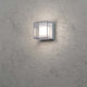 Sanremo LED Außenwandleuchte Grau an einer strukturierten Wand montiert, strahlendes Licht von der Lampe.