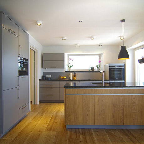 Moderne Küche mit Holz- und grauen Oberflächen, LED-Beleuchtung und einem eleganten Kücheninsel-Design.