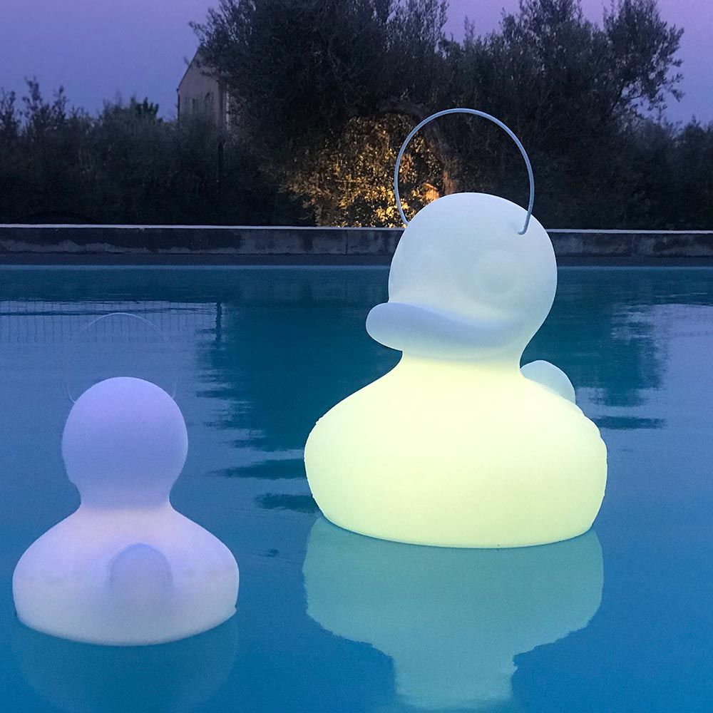 Schwimmfähige weiße Akku-LED-Lampe Duck-Duck XL auf einem Pool, leuchtend und einladend.