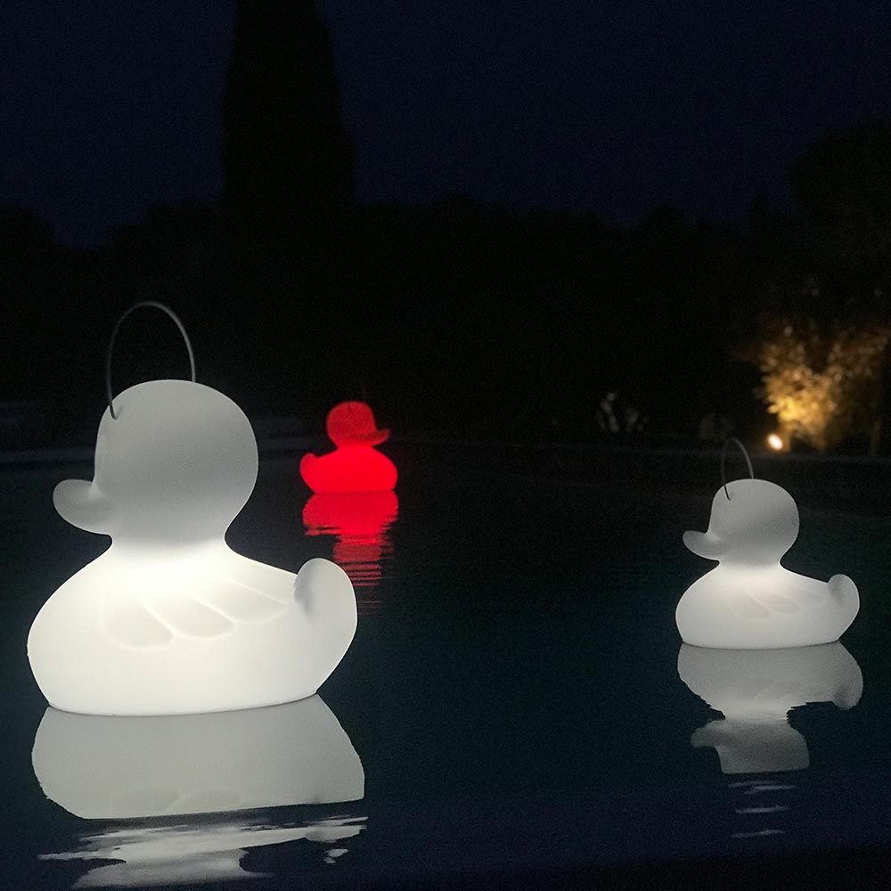 Schwimmfähige Akku-LED-Lampe Duck-Duck XL in Weiß und Rot im Pool bei Nacht.