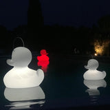 Schwimmfähige Akku-LED-Lampe Duck-Duck XL in Weiß und Rot im Pool bei Nacht.