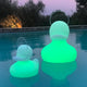 Schwimmfähige Akku-LED-Ente Duck-Duck S Gelb leuchtet grün im Wasser, perfekt für Garten und Freizeit.
