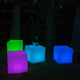 Schwimmfähiger LED-Lichtwürfel in verschiedenen Farben, dekorativ mit LOVE Schriftzug im Garten.