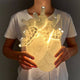 Seletti Heart Wandleuchte & Vase mit weichem Licht in Herzform in den Händen einer Person