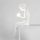 Seletti Innerglow Mini LED-Tischleuchte Mädchen dimmbar – weiße Harzfigur eines sitzenden Mädchens, hält leuchtende Kugel, dimmbares Wohnraum-Design