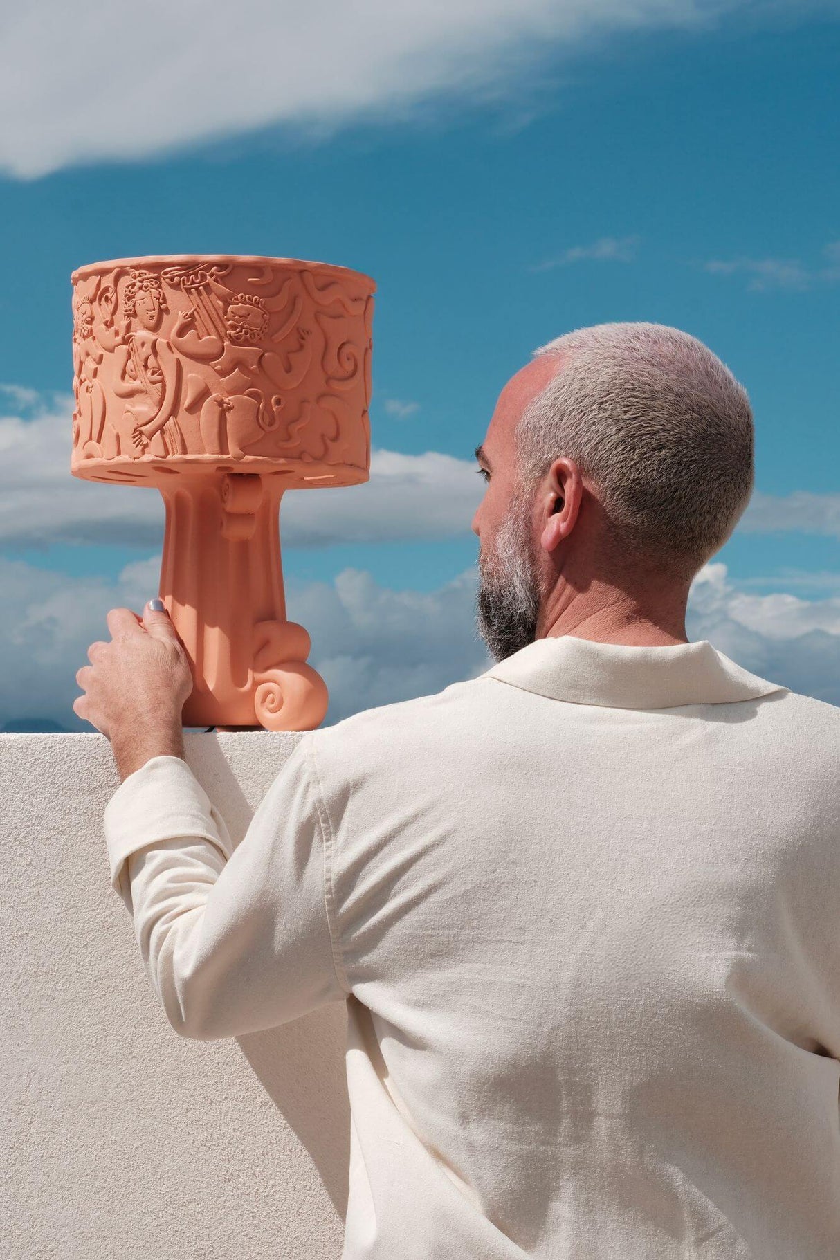 Seletti Magna Graecia DEA Outdoor-Tischleuchte Terracotta auf Mauer mit Designer im mediterranen Außenbereich