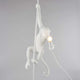 Seletti Monkey Ceiling Pendelleuchte Weiß mit Affe, der an Seil hängt und Lampe hält.