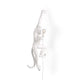 Seletti Monkey Wandleuchte hängend linke Hand Weiß mit verspieltem Affen, der an der Wand hängt und eine Lampe hält.