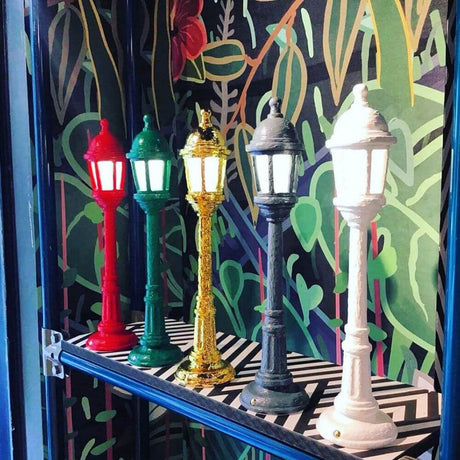 Seletti Street bordlampe i forskjellige farger på en hylle, inspirert av retrostil og dioramaer.