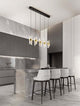 Seneca LED Pendelleuchte Balken 82cm 5-flammig 3000K Schwarz, Gold über modernem Esstisch in stilvollem Raum.