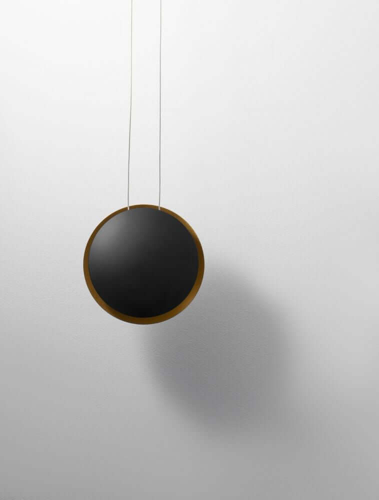 Shell LED Pendelleuchte Ø 20cm 3000K Schwarz, Gold an einer Wand, modernes Design mit goldfarbenem Rahmen.