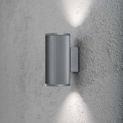 Siracusa utendørs vegglampe, grå, klart glass, reflektor på en vegg med to lysstråler.