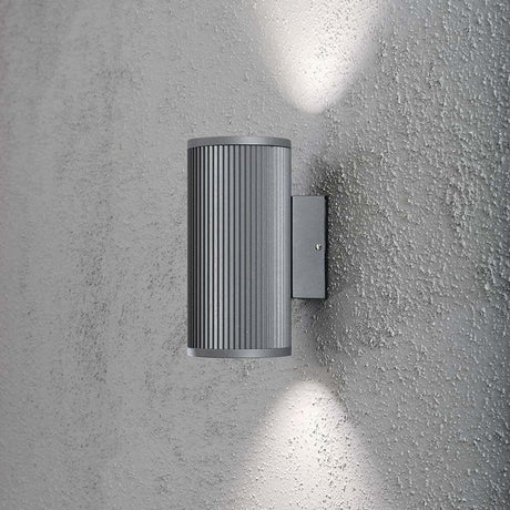 Siracusa Buitenwandlamp Grijs, helder glas, reflector aan een muur met twee lichtstralen.