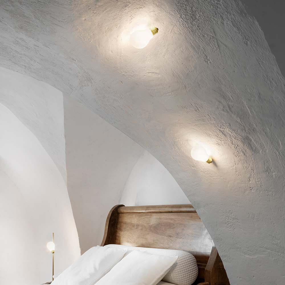 Slamp Einbau-Wandlampe Glühbirne Idea Applique Weiß an einer Wand über einem Bett installiert.