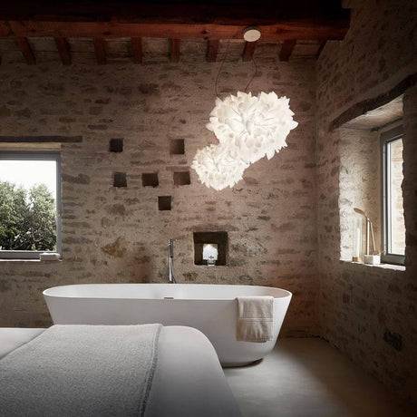 Slamp Pendelleuchte Veli Foliage Weiß erhellt modernes Badezimmer mit eleganter Badewanne.