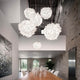Slamp Pendelleuchte Veli Foliage Weiß im modernen Esszimmer mit Holztisch und hellen Wänden.