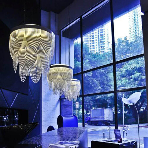 Lampada a sospensione Slamp Ceremony Small Prisma Trasparente in un interno moderno con grandi finestre.