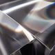 Detailaufnahme der transparenten Folie der Slamp Hängeleuchte Gemmy Prisma Transparent.
