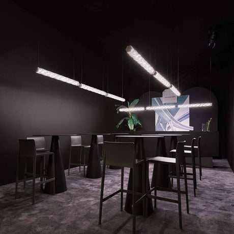 Slamp LED Hängeleuchte Hugo Architectural System 24V in modernem Raum mit eleganten Möbeln und Pflanzen.