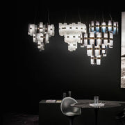 Slamp LED Suspension La Lollo Medium 2500 lm 2700 K Gradient dans un espace élégant avec un mur sombre.