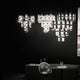 Slamp LED Pendelleuchte La Lollo Large 5000lm 2700K Weiß im stilvollen Raum mit schwarzen Wänden.
