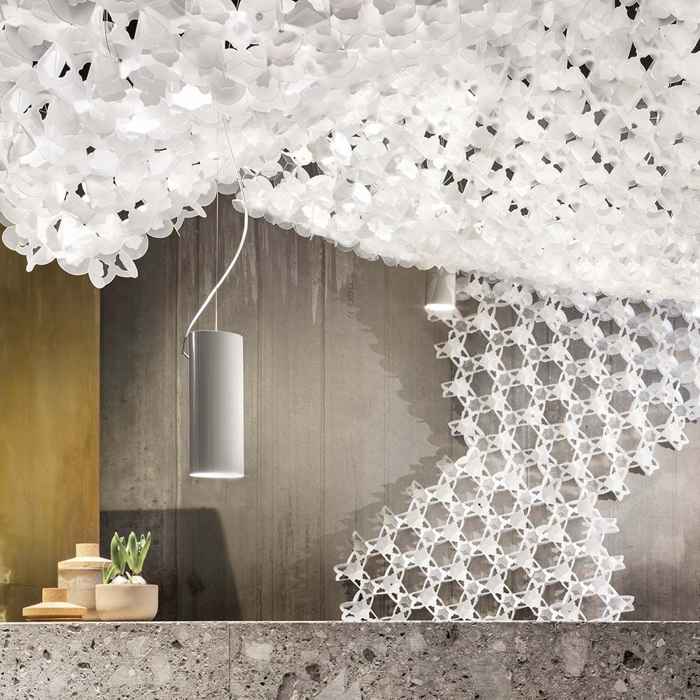 Designleuchte Slamp Nuvem mit modularem, skulpturalem Deckenelement und Spotlight in einem modernen Raum.