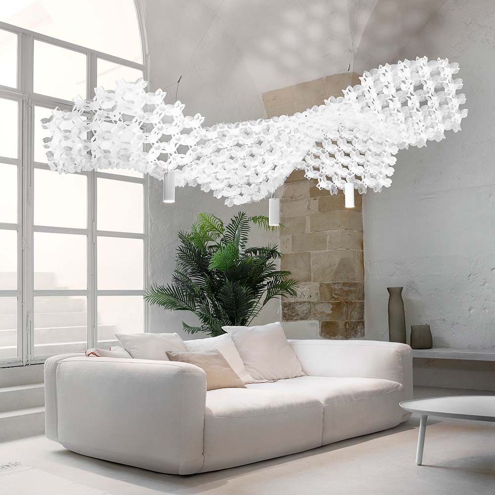 Moderne Slamp Nuvem Lampe in Weiß, hängend über einem eleganten Sofa im hellen Raum.