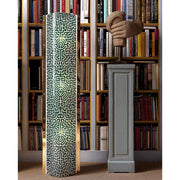 Slamp Golvlampa Labirynth Extra Large Tube Grön, Guld i ett stiligt rum med bokhylla i bakgrunden.